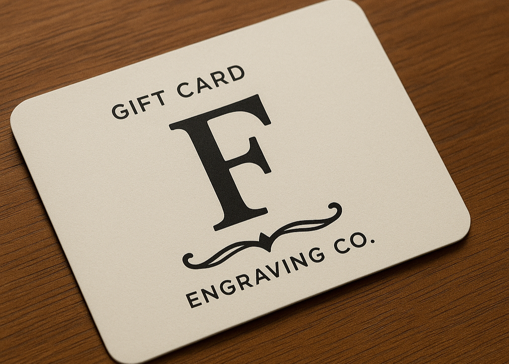 Gift card from F Engraving Co. on a wooden surface