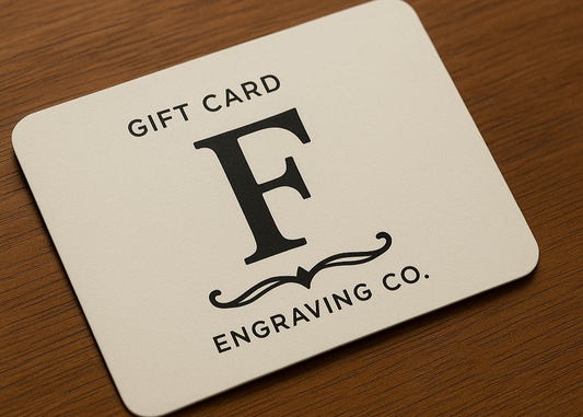Gift card from F Engraving Co. on a wooden surface